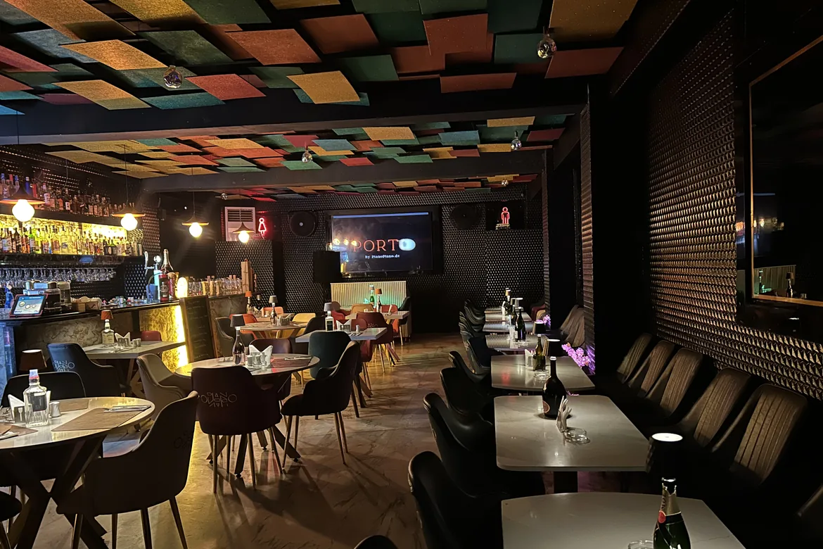Porto : le bar, les tables de marbre et le plafond de panneaux colorés.